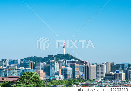 Scenic skyline of downtown Seoul featuring Namsan Seoul Tower and skyscrapers under a clear blue sky with white clouds on a summer day Scenic skyline of downtown Seoul featuring Namsan Seoul Tower and skyscrapers under a clear blue sky with white clouds on a summer day 140253363