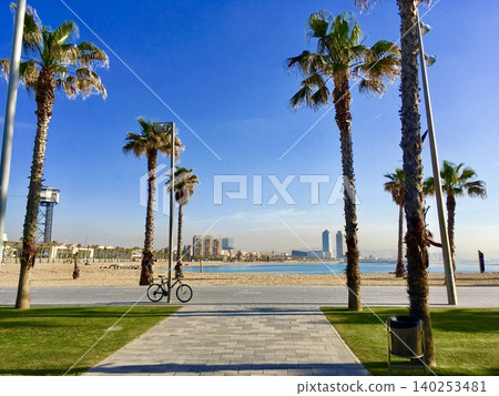 A seaside promenade in Barcelona, where the blue sky and palm trees create a beautiful scene. A seaside promenade in Barcelona, where the blue sky and palm trees create a beautiful scene. 140253481