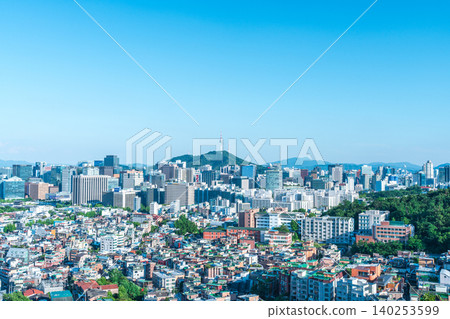 Scenic skyline of downtown Seoul featuring Namsan Seoul Tower and skyscrapers under a clear blue sky with white clouds on a summer day 140253599