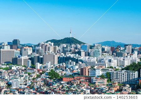 Scenic skyline of downtown Seoul featuring Namsan Seoul Tower and skyscrapers under a clear blue sky with white clouds on a summer day Scenic skyline of downtown Seoul featuring Namsan Seoul Tower and skyscrapers under a clear blue sky with white clouds on a summer day 140253603