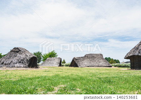 在晴朗的藍天下,一座重建的平安時代半地穴居所和比來出考古遺址。 在晴朗的藍天下,一座重建的平安時代半地穴居所和比來出考古遺址。 140253681