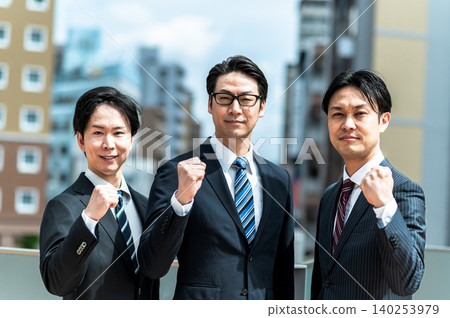 Three men in suits are clenching their fists and looking positive. Three men in suits are clenching their fists and looking positive. 140253979