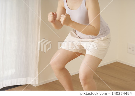 一位女士在家做深蹲 140254494