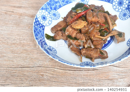 spicy fried fat pork belly with vegetable and lemon leaf in shrimp paste sauce on plate 140254931