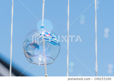A refreshing glass wind chime with a dolphin pattern that stands out against the blue sky. A refreshing glass wind chime with a dolphin pattern that stands out against the blue sky. 140255200