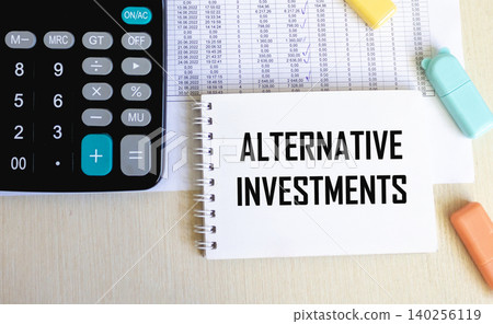 notebook next to the calculator says Alternative investments.There are financial documents nearby notebook next to the calculator says Alternative investments.There are financial documents nearby 140256119