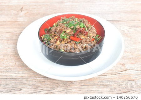 spicy stir fried chop beef meat with chili and basil in bowl on plate spicy stir fried chop beef meat with chili and basil in bowl on plate 140256670