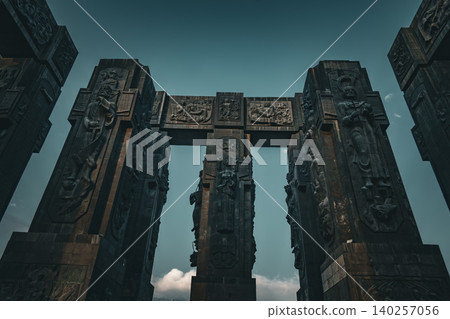 Dramatic Low Angle View of Monumental Stone Gateway with Historical Reliefs 140257056