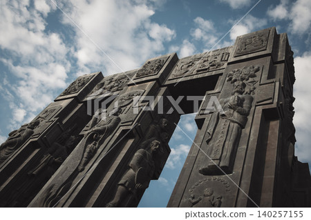 Dramatic Low Angle View of Monumental Stone Gateway with Historical Reliefs Dramatic Low Angle View of Monumental Stone Gateway with Historical Reliefs 140257155