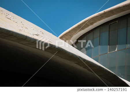 Abstract Modern Architectural Curves and Glass Facade Against Blue Sky Abstract Modern Architectural Curves and Glass Facade Against Blue Sky 140257191