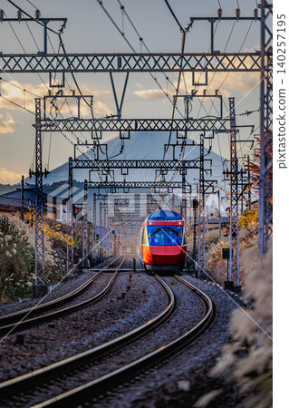 The Odakyu Romancecar train speeds along the railway line, where pampas grass shines brightly, with Mount Fuji in the background. The Odakyu Romancecar train speeds along the railway line, where pampas grass shines brightly, with Mount Fuji in the background. 140257195