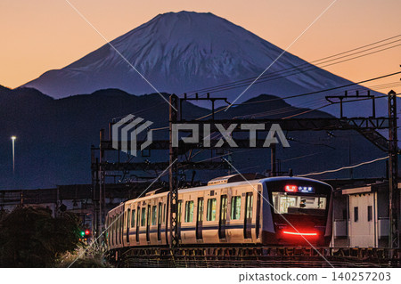 Mount Fuji illuminated in the evening light, and the charming scenery of the Odakyu train. Mount Fuji illuminated in the evening light, and the charming scenery of the Odakyu train. 140257203