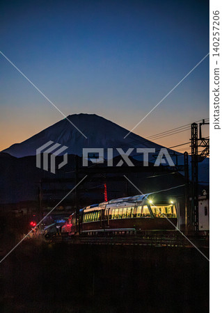 小田急浪漫列車 GSE 疾馳在暮色籠罩的景色中,富士山在遠處巍峨聳立。 小田急浪漫列車 GSE 疾馳在暮色籠罩的景色中,富士山在遠處巍峨聳立。 140257206