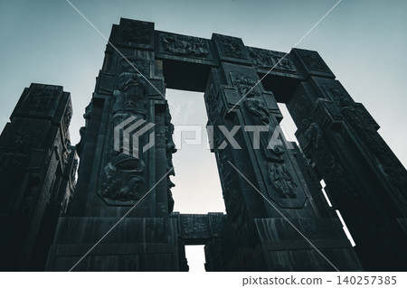 Ancient Monumental Stone Gateway with Historical Relief Sculptures and Cultural Heritage Figures Ancient Monumental Stone Gateway with Historical Relief Sculptures and Cultural Heritage Figures 140257385