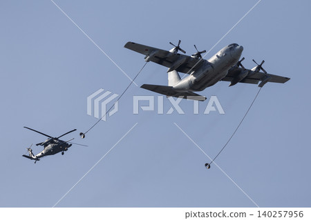 A demonstration of aerial refueling between a C-130 transport aircraft and a UH-60 rescue helicopter. A demonstration of aerial refueling between a C-130 transport aircraft and a UH-60 rescue helicopter. 140257956