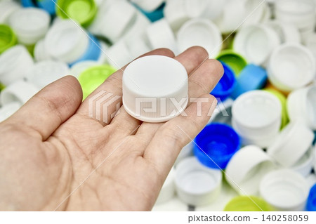 plastic bottle cap and hand plastic bottle cap and hand 140258059