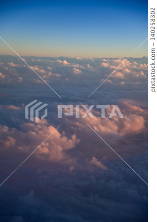 Looking through the airplane window with the sunset sky. Romantic sky, golden hours, colorful sunset sky with clouds. Stunning cloudscape and skyscape. Nature concept. For background use. Looking through the airplane window with the sunset sky. Romantic sky, golden hours, colorful sunset sky with clouds. Stunning cloudscape and skyscape. Nature concept. For background use. 140258302