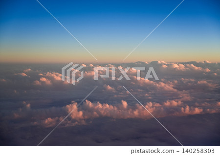 Looking through the airplane window with the sunset sky. Romantic sky, golden hours, colorful sunset sky with clouds. Stunning cloudscape and skyscape. Nature concept. For background use. Looking through the airplane window with the sunset sky. Romantic sky, golden hours, colorful sunset sky with clouds. Stunning cloudscape and skyscape. Nature concept. For background use. 140258303