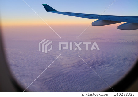 Looking through the airplane window with the sunset sky. Romantic sky, golden hours, colorful sunset sky with clouds. Stunning cloudscape and skyscape. Nature concept. For background use. 140258323