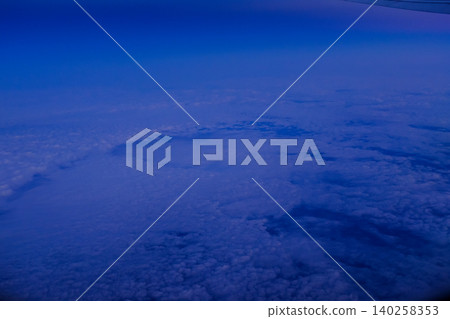Looking through the airplane window with the sunset sky. Romantic sky, golden hours, colorful sunset sky with clouds. Stunning cloudscape and skyscape. Nature concept. For background use. Looking through the airplane window with the sunset sky. Romantic sky, golden hours, colorful sunset sky with clouds. Stunning cloudscape and skyscape. Nature concept. For background use. 140258353