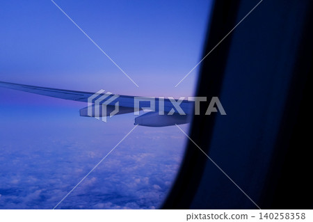 Looking through the airplane window with the sunset sky. Romantic sky, golden hours, colorful sunset sky with clouds. Stunning cloudscape and skyscape. Nature concept. For background use. 140258358