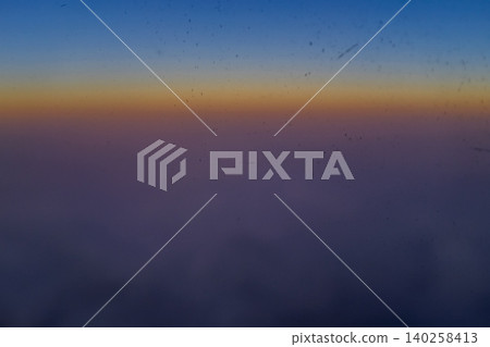 Sunset sky from the airplane window in blur. Romantic sky, golden hours, colorful sunset sky with clouds. Stunning cloudscape and skyscape. Nature and travel concept. For background use. Sunset sky from the airplane window in blur. Romantic sky, golden hours, colorful sunset sky with clouds. Stunning cloudscape and skyscape. Nature and travel concept. For background use. 140258413