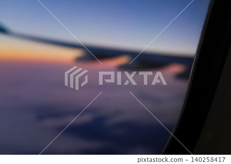 Sunset sky from the airplane window in blur. Romantic sky, golden hours, colorful sunset sky with clouds. Stunning cloudscape and skyscape. Nature and travel concept. For background use. Sunset sky from the airplane window in blur. Romantic sky, golden hours, colorful sunset sky with clouds. Stunning cloudscape and skyscape. Nature and travel concept. For background use. 140258417