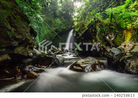 Aerial view of a hidden waterfall deep within the lush tropical rainforest of Mount Daun Aerial view of a hidden waterfall deep within the lush tropical rainforest of Mount Daun 140258613