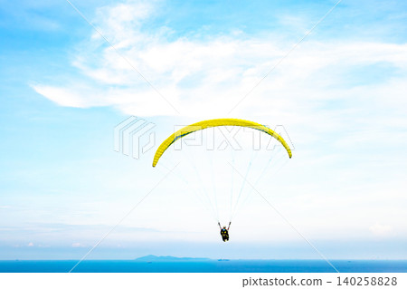 A paraglider flies in the blue sky. A paraglider flies in the blue sky. 140258828