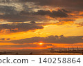 Dramatic sunset over industrial port with cargo cranes and ships on the water 140258864