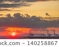 Dramatic sunset over industrial port with cranes and fiery clouds 140258867
