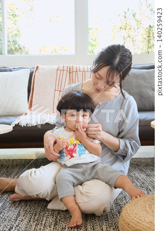 A mother tries to correct her habit of holding her child in the living room and leaving their mouth open. A mother tries to correct her habit of holding her child in the living room and leaving their mouth open. 140259423