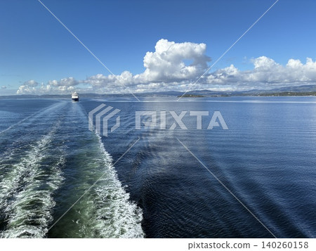 A boat trip through the Nordic fjords guided by a blue wake 140260158
