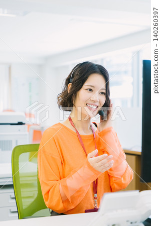 辦公室裡,一名戴著耳機的女接線生正在接聽電話。 辦公室裡,一名戴著耳機的女接線生正在接聽電話。 140260397