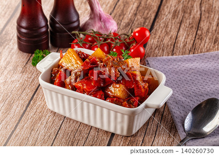 Hearty Beef Stew with Potatoes and Red Peppers in Ceramic Dish 140260730