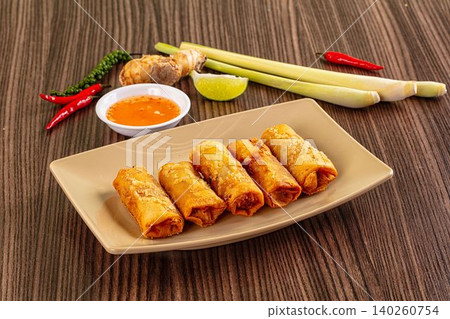 Golden fried spring rolls with spicy dipping sauce and fresh Asian ingredients Golden fried spring rolls with spicy dipping sauce and fresh Asian ingredients 140260754