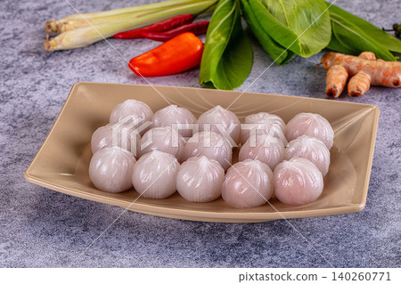 Steamed shrimp dumplings har gow with fresh thai herbs and spices on gray stone background Steamed shrimp dumplings har gow with fresh thai herbs and spices on gray stone background 140260771