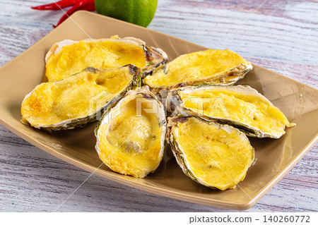 Baked oysters with cheese sauce on plate 140260772