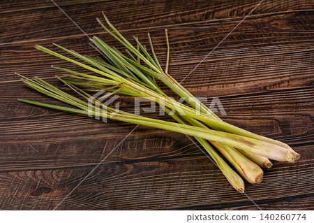 Fresh green lemongrass stalks on dark brown wooden table background Fresh green lemongrass stalks on dark brown wooden table background 140260774