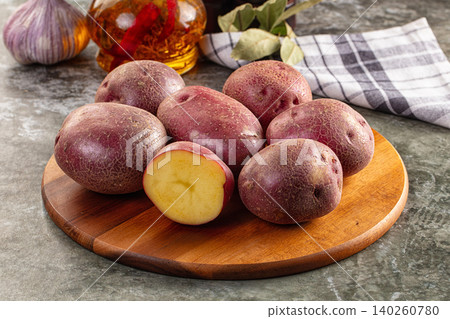 Fresh red potatoes on wooden board with garlic and oil Fresh red potatoes on wooden board with garlic and oil 140260780