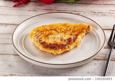 Golden fried fish fillet with crispy breading on white plate with fork Golden fried fish fillet with crispy breading on white plate with fork 140260803