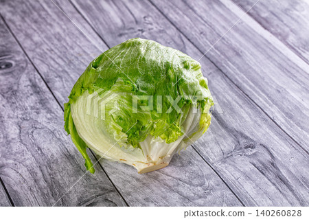 Fresh green iceberg lettuce head on gray wooden table Fresh green iceberg lettuce head on gray wooden table 140260828