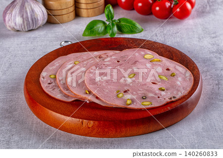 Sliced mortadella with pistachios on wooden board Sliced mortadella with pistachios on wooden board 140260833