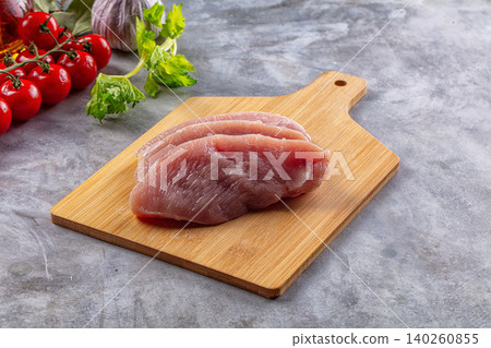 Raw chicken breast fillets on wooden cutting board with vegetables Raw chicken breast fillets on wooden cutting board with vegetables 140260855