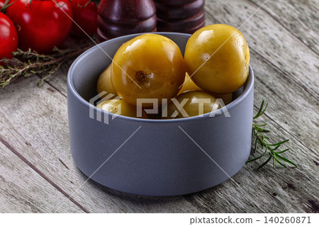 Yellow tomatoes in a blue bowl on a wooden table with rosemary and red tomatoes Yellow tomatoes in a blue bowl on a wooden table with rosemary and red tomatoes 140260871