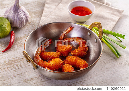 Fried breaded shrimp in metal bowl with fresh lime, garlic, chili, and dipping sauce on rustic table Fried breaded shrimp in metal bowl with fresh lime, garlic, chili, and dipping sauce on rustic table 140260911