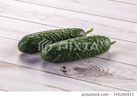 Two fresh green cucumbers on white wooden surface Two fresh green cucumbers on white wooden surface 140260923