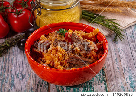 Couscous with meat and vegetables in red bowl Couscous with meat and vegetables in red bowl 140260986