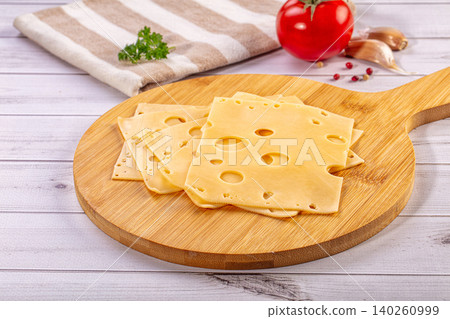 Slices of Swiss Cheese on Wooden Board with Fresh Ingredients Slices of Swiss Cheese on Wooden Board with Fresh Ingredients 140260999