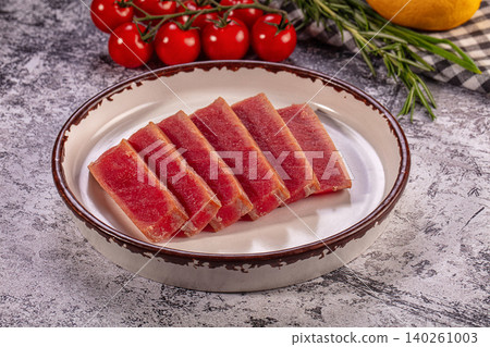 Sliced smoked tuna on ceramic plate with cherry tomatoes Sliced smoked tuna on ceramic plate with cherry tomatoes 140261003